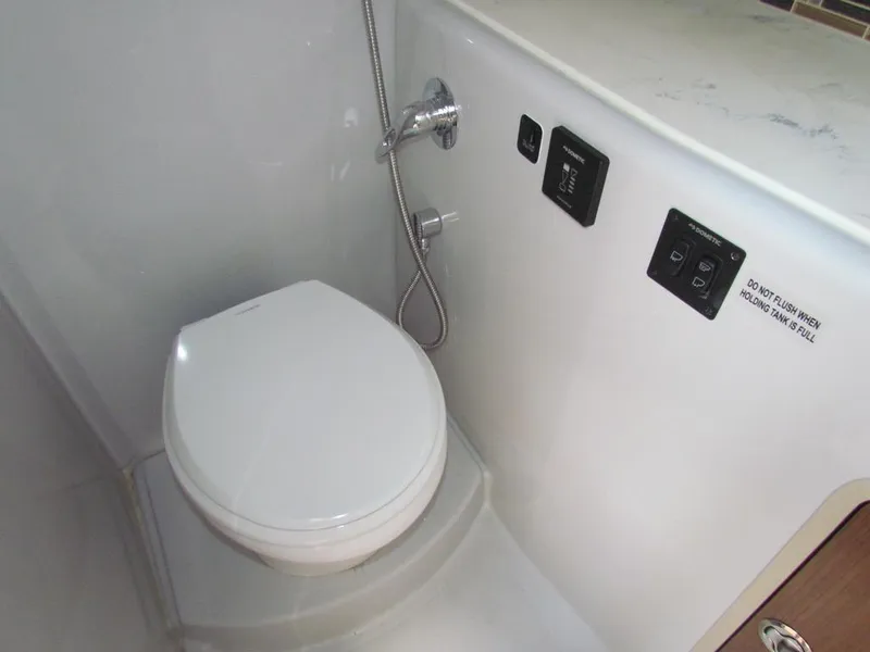 Slide: The Image of 2020 Cruisers Yachts 35 Express bathroom with modern toilet and control panel. - 38