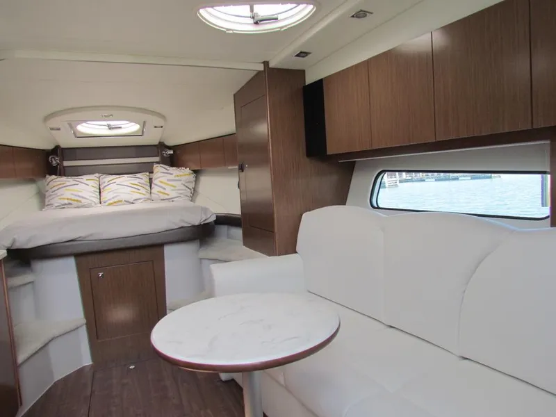 Slide: The Image of 2020 Cruisers Yachts 35 Express interior with bed, seating, and wood cabinetry. - 6