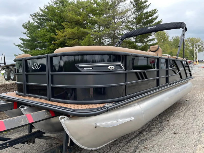 Slide: The Image of 2025 Bentley Pontoons Elite 223 Admiral on trailer, sleek black design, outdoor setting. - 1