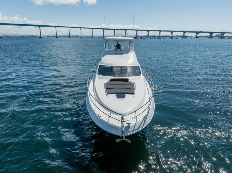 Slide: The Image of 2005 Sea Ray 550 Sedan Bridge yacht cruising under a clear blue sky. - 1