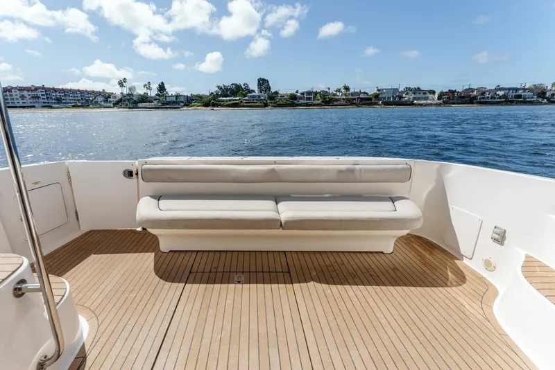 Slide: The Image of 2005 Sea Ray 550 Sedan Bridge yacht deck with seating, overlooking calm waters. - 10