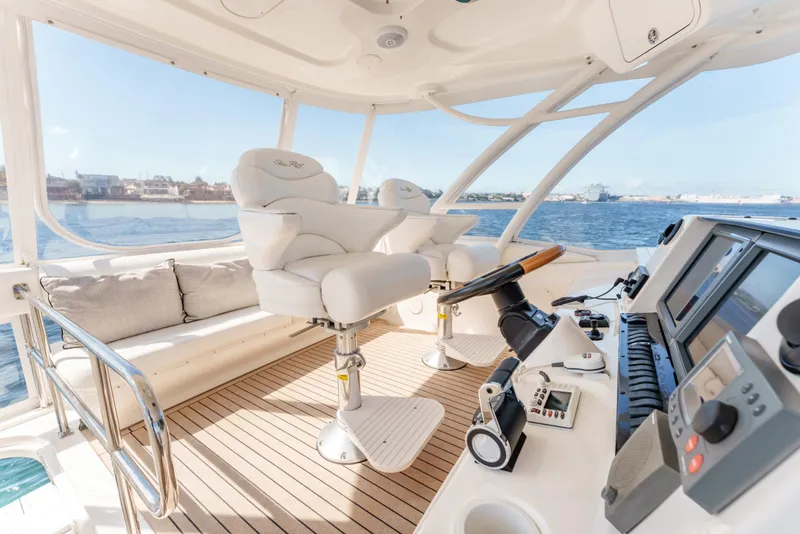 Slide: The Image of 2005 Sea Ray 550 Sedan Bridge yacht interior with helm, white seats, and navigation equipment. - 5