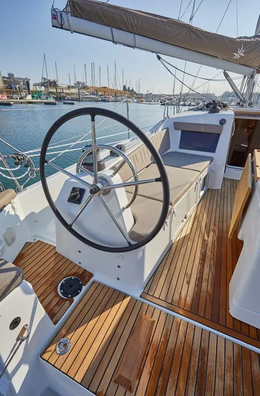 Slide: The Image of 2025 Jeanneau Sun Odyssey 410 sailboat cockpit with wooden deck and steering wheel. - 13