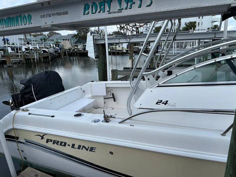 Slide: The Image of 2006 Pro-Line 24 Walk boat docked at a marina, featuring sleek design and spacious deck. - 13
