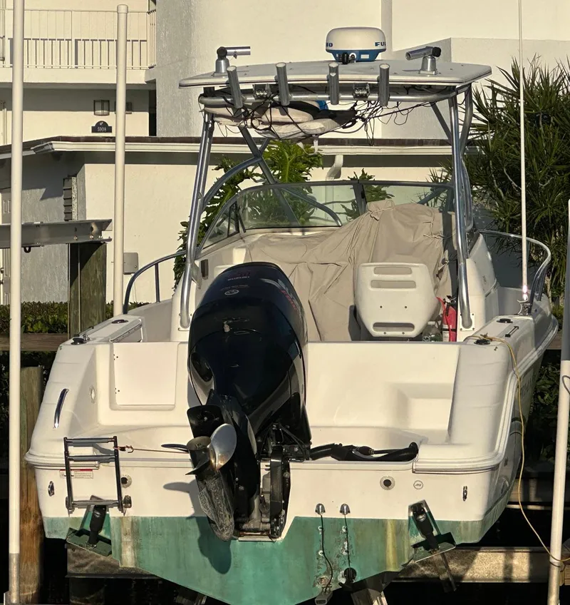 Slide: The Image of 2006 Pro-Line 24 Walk boat with outboard motor, docked in a marina. - 14
