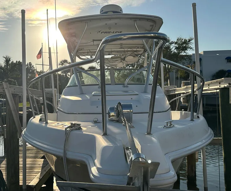 Slide: The Image of 2006 Pro-Line 24 Walk boat docked at sunset with sleek design and chrome railings. - 4