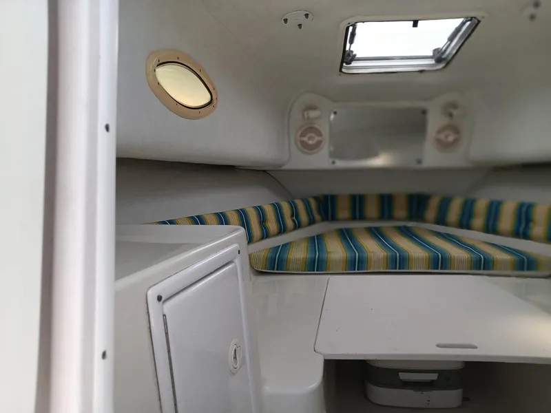 Slide: The Image of Interior of 2006 Pro-Line 24 Walk boat with striped cushions and porthole window. - 6