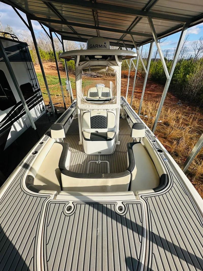 Slide: The Image of 2021 Tidewater 2500 Carolina Bay boat under a metal canopy, featuring a spacious deck. - 10