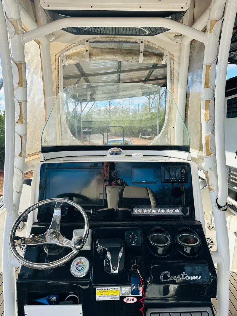 Slide: The Image of 2021 Tidewater 2500 Carolina Bay boat console with steering wheel and controls. - 7