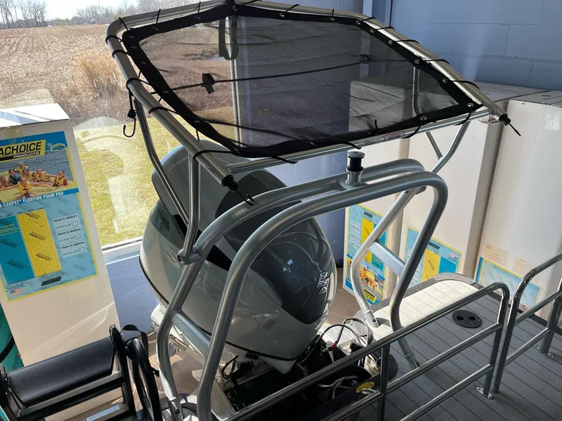 Slide: The Image of 2025 Bentley Pontoons Elite 253 Swingback with canopy and motor, displayed indoors. - 10