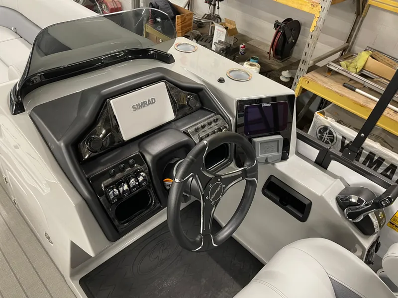 Slide: The Image of 2025 Bentley Pontoons Elite 253 Swingback dashboard with steering wheel and navigation system. - 7