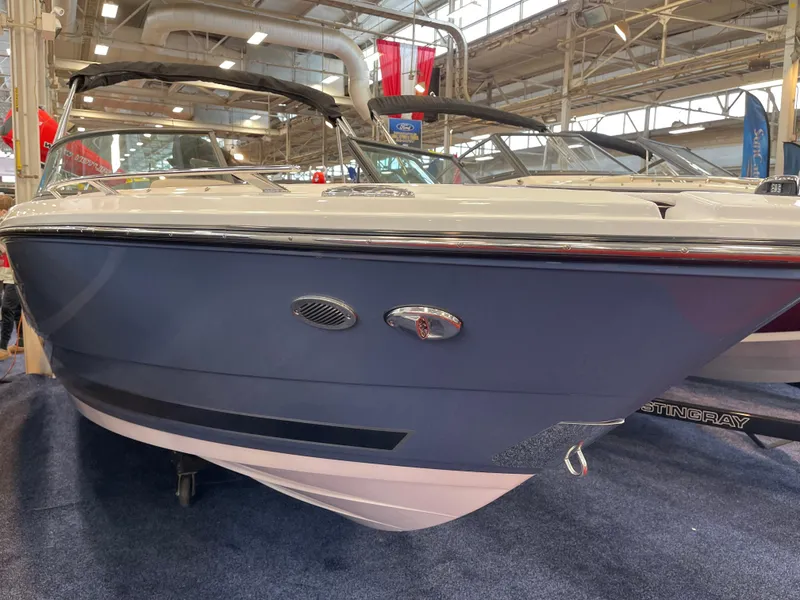 Slide: The Image of 2025 Monterey 218 SS boat displayed indoors at a boat show. - 2