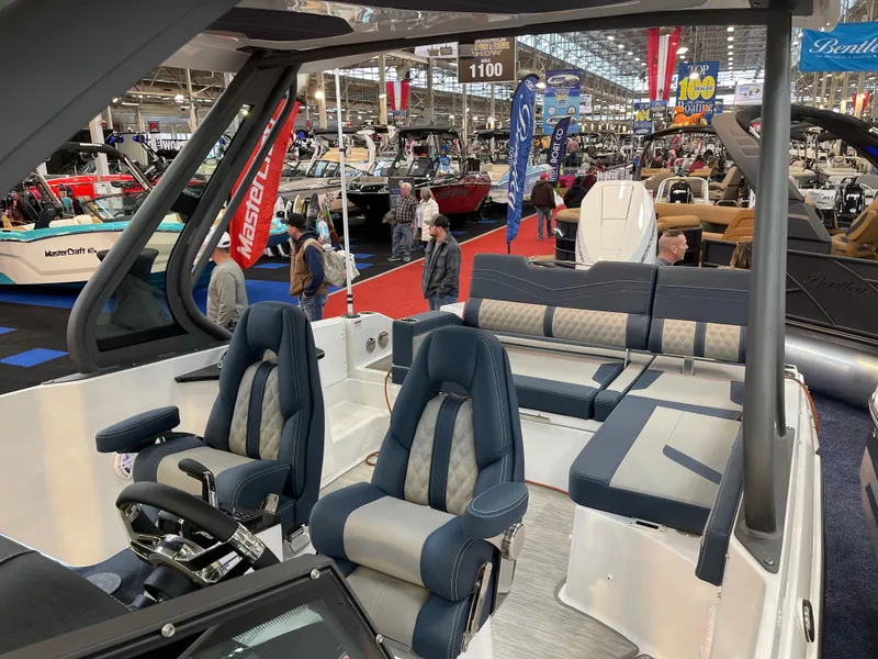 Slide: The Image of 2025 Monterey Elite 27 OB boat interior at a boat show, featuring luxurious seating. - 12