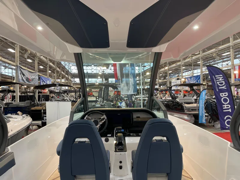 Slide: The Image of 2025 Monterey Elite 27 OB boat interior at a boat show, featuring dual seats and modern dashboard. - 13
