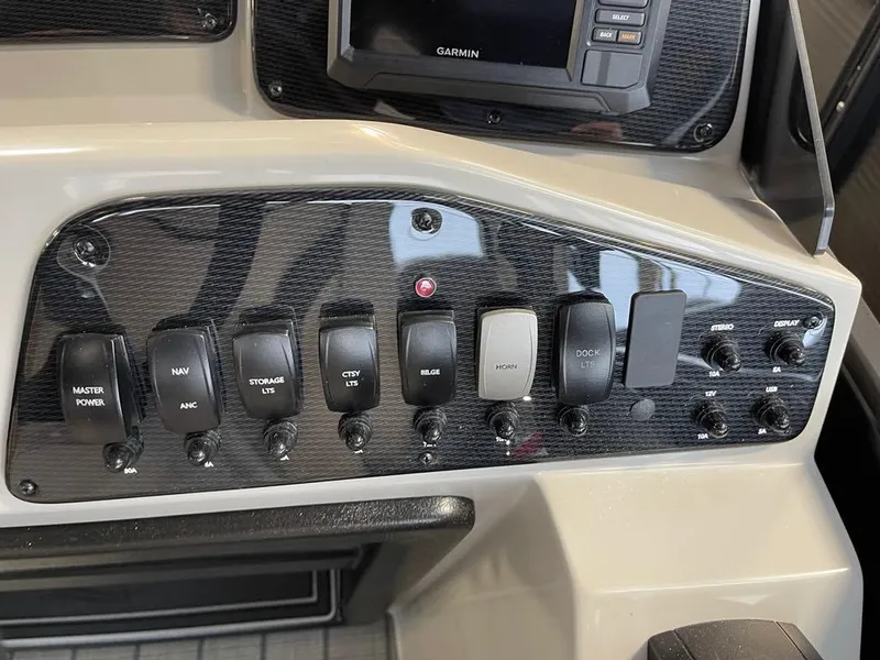 Slide: The Image of Control panel of 2025 SunCatcher Select 322RC boat with various switches and a Garmin device. - 11