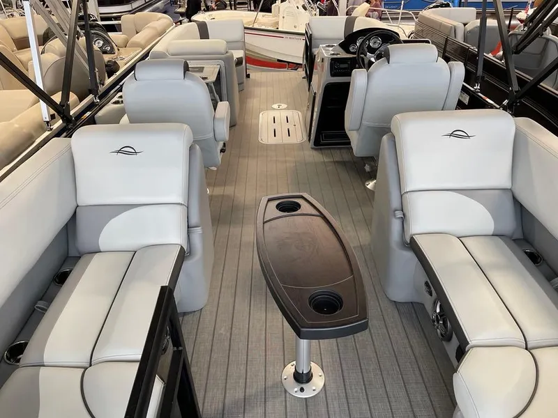 Slide: The Image of 2025 SunCatcher Select 322RC pontoon boat interior with gray seating and central table. - 17