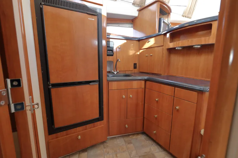 Slide: The Image of 2002 Carver 346 Motor Yacht kitchen area with wooden cabinets. - 16
