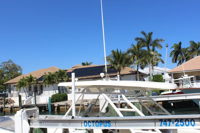 Slide: The Image of 2008 Pursuit S 310 Sport boat docked near waterfront homes and palm trees. - 12