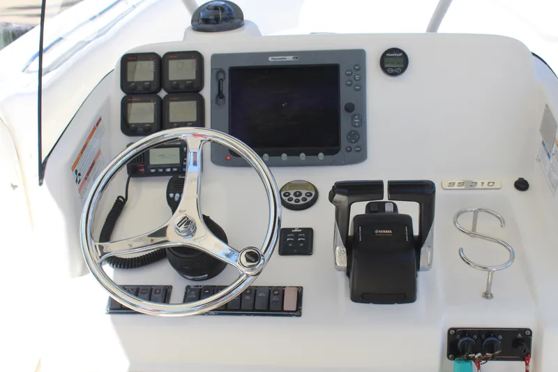 Slide: The Image of Control panel of a 2008 Pursuit S 310 Sport boat with steering wheel and navigation equipment. - 18