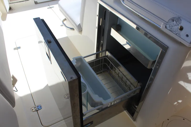 Slide: The Image of Open storage compartment on 2008 Pursuit S 310 Sport boat, featuring a pull-out drawer. - 21