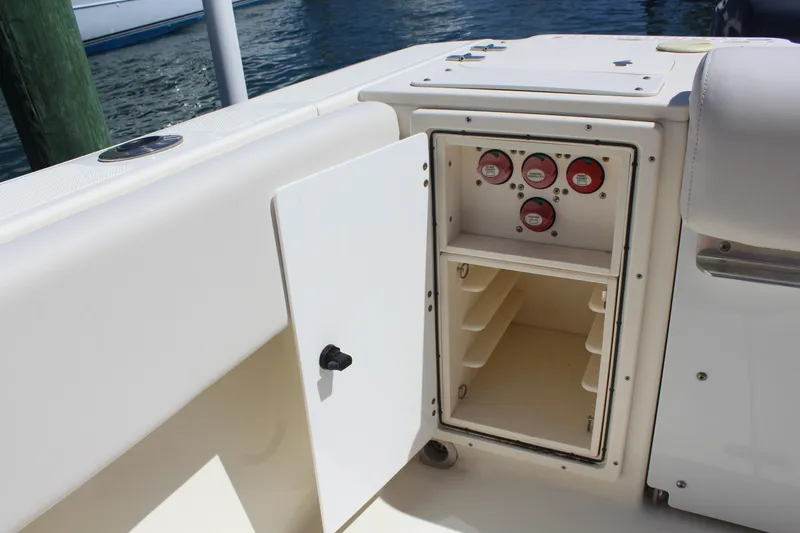 Slide: The Image of 2008 Pursuit S 310 Sport boat storage compartment with open door and gauges. - 28