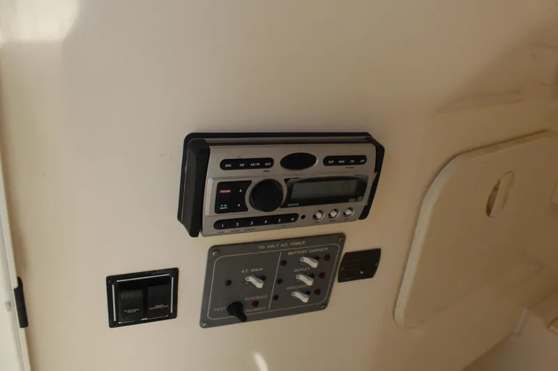 Slide: The Image of 2008 Pursuit S 310 Sport boat control panel with stereo system and switches. - 29