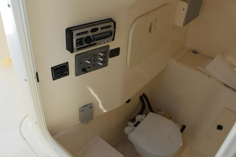 Slide: The Image of Interior of 2008 Pursuit S 310 Sport boat featuring a compact marine toilet and control panel. - 30