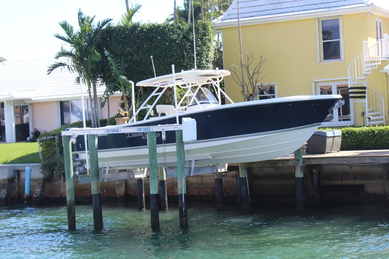 Slide: The Image of 2008 Pursuit S 310 Sport boat docked near waterfront homes. - 6
