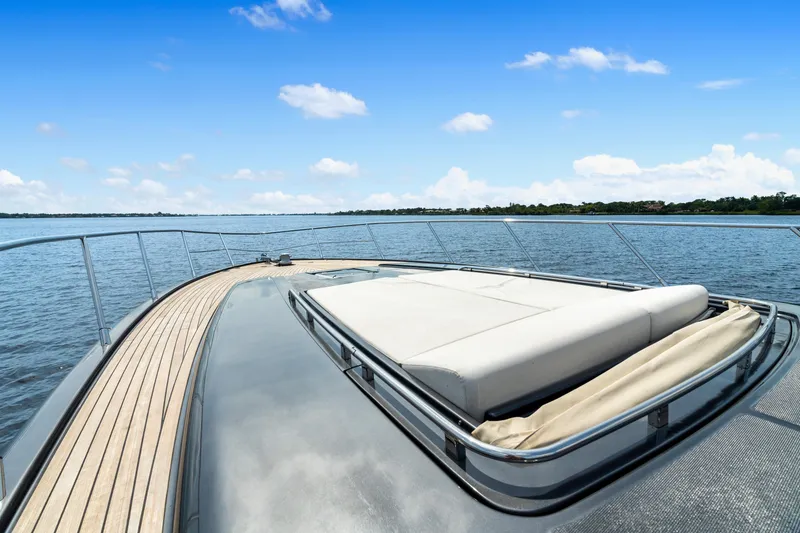 Slide: The Image of Luxurious 2015 Riva 63 Virtus yacht deck with sunbed, overlooking serene waters. - 13