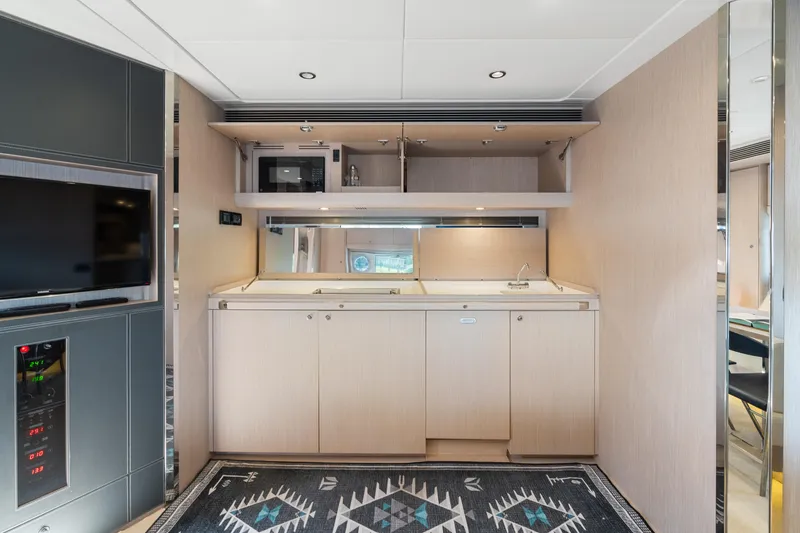 Slide: The Image of Interior of 2015 Riva 63 Virtus yacht featuring a modern kitchenette and stylish decor. - 24