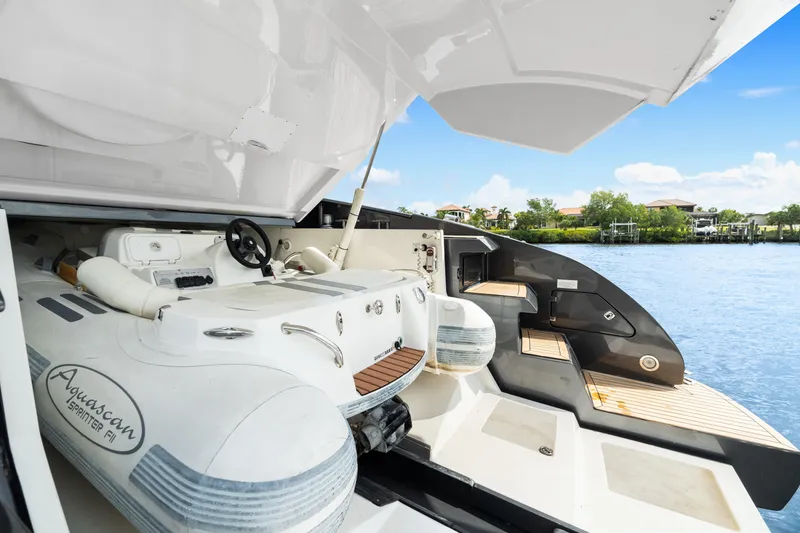 Slide: The Image of 2015 Riva 63 Virtus yacht with Aquascan tender, docked by a scenic waterfront. - 44