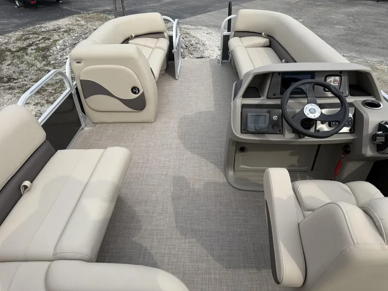 Slide: The Image of 2025 Sun Tracker Party Barge 18 DLX interior with beige seating and steering console. - 10
