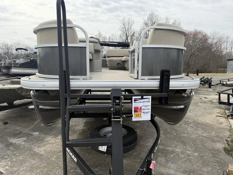 Slide: The Image of 2025 Sun Tracker Party Barge 18 DLX pontoon boat on trailer, outdoor setting. - 11