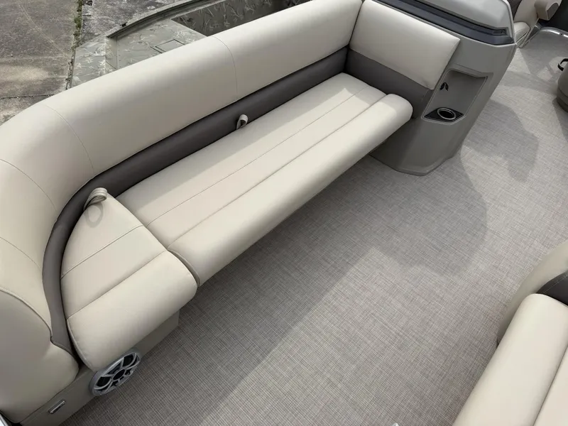 Slide: The Image of 2025 Sun Tracker Party Barge 18 DLX interior with beige seating and carpeted flooring. - 4