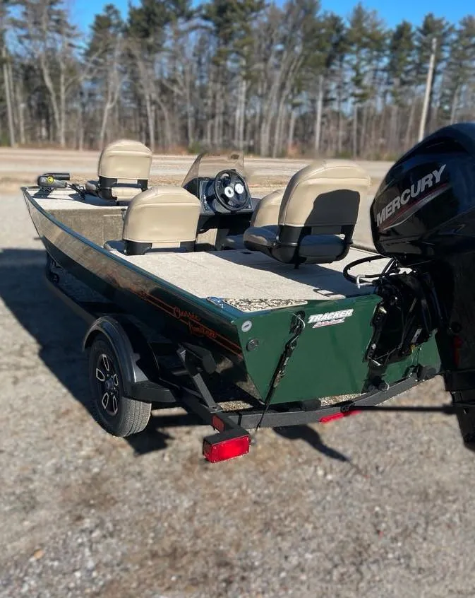 Slide: The Image of 2025 Tracker Bass Tracker Classic Limited boat with Mercury engine, parked outdoors. - 4