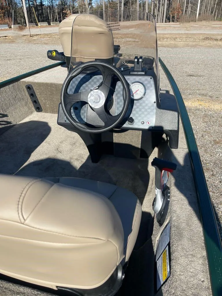 Slide: The Image of 2025 Tracker Bass Tracker Classic Limited boat interior with steering wheel and beige seating. - 5