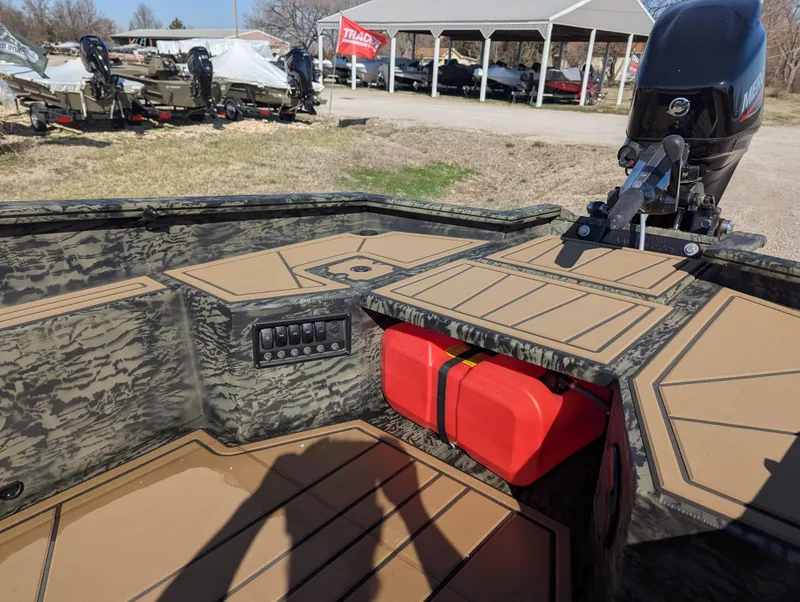 Slide: The Image of 2025 Tracker Grizzly 1650 T Prairie Wings Edition boat interior with camouflage design and red fuel tank. - 12