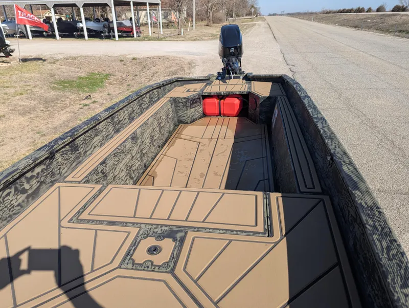 Slide: The Image of 2025 Tracker Grizzly 1650 T Prairie Wings Edition boat on a rural road. - 14