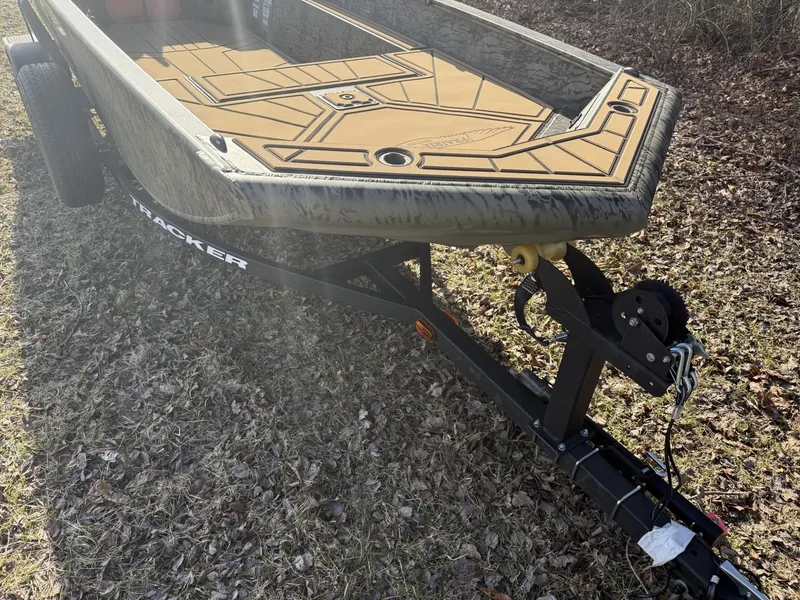Slide: The Image of 2025 Tracker Grizzly 1650 T Prairie Wings Edition boat on trailer, parked on grass. - 9