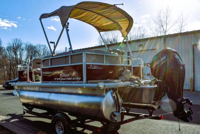 Slide: The Image of 2025 Sun Tracker Bass Buggy 16 XL Select pontoon boat with canopy and Mercury outboard motor. - 4