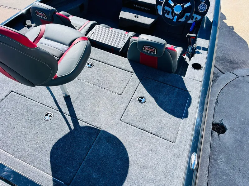 Slide: The Image of 2024 Ranger RT198P boat interior with gray and red seating, steering wheel, and storage compartments. - 39