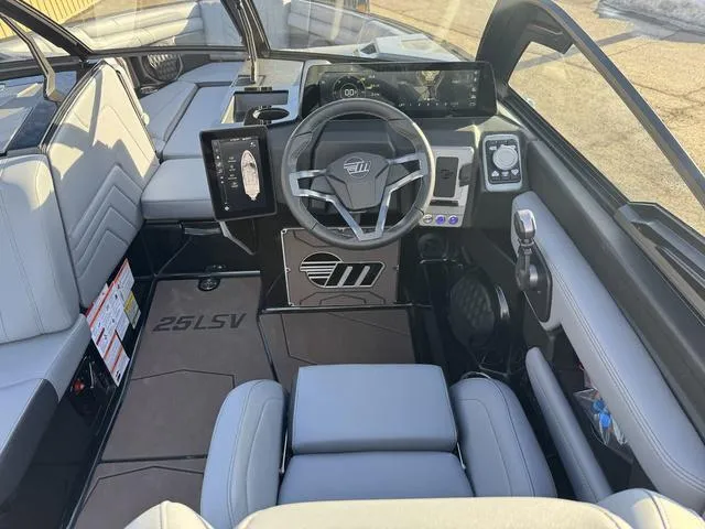 Slide: The Image of Interior of 2025 Malibu 25 LSV boat with modern dashboard and steering wheel. - 11
