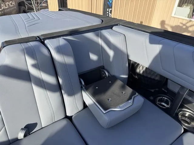 Slide: The Image of 2025 Malibu 25 LSV boat interior with gray seating and cup holders. - 14
