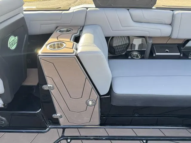 Slide: The Image of Interior of 2025 Malibu 25 LSV boat with gray seating and cup holders. - 19