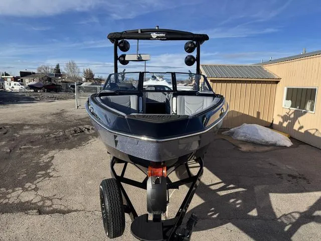 Slide: The Image of 2025 Malibu 25 LSV boat on trailer, parked outdoors under clear blue sky. - 4