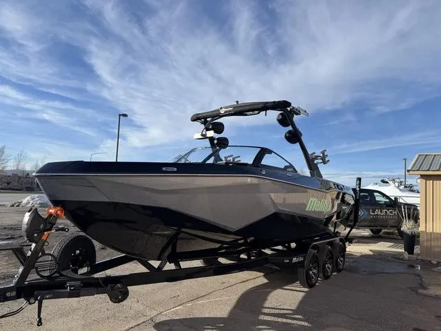 Slide: The Image of 2025 Malibu 25 LSV boat on trailer under clear blue sky. - 5