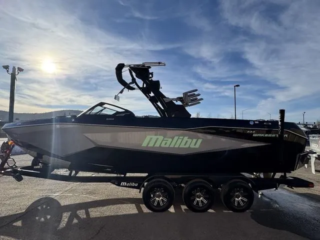 Slide: The Image of 2025 Malibu 25 LSV boat on trailer under a bright sky. - 6