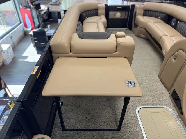 Slide: The Image of 2025 Barletta Lusso L25UC boat interior with beige seating and foldable table. - 11