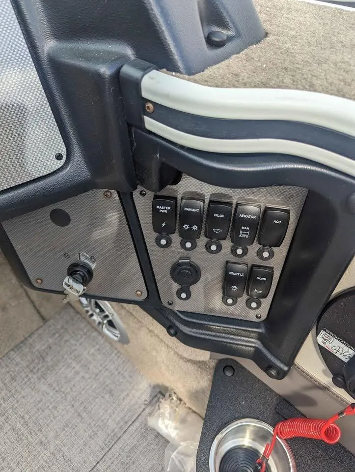Slide: The Image of Control panel of 2024 Alumacraft Trophy 185 boat with switches and key ignition. - 16