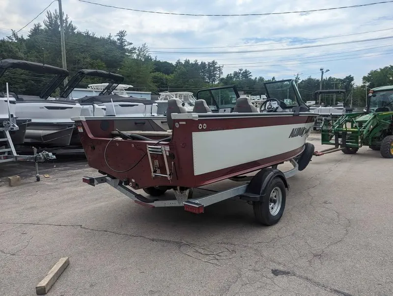 Slide: The Image of 2024 Alumacraft Trophy 185 boat on trailer in outdoor lot. - 2